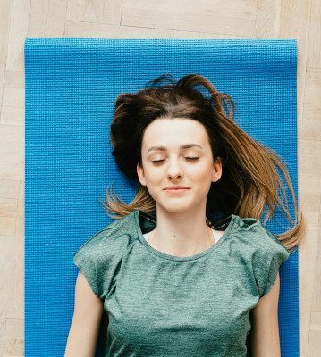 Image of woman sleeping on a yoga mat.